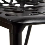 LeisureMod Devon 5-Piece Outdoor Dining Set - Round Glass Table with 4 Black Flower Design Stackable Chairs